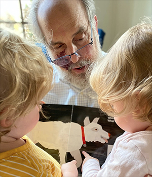 Larry Susskind reads a picture book to two children.
