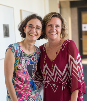 Leslie Kolodziejski and a graduate student laugh while standing together for a photo.