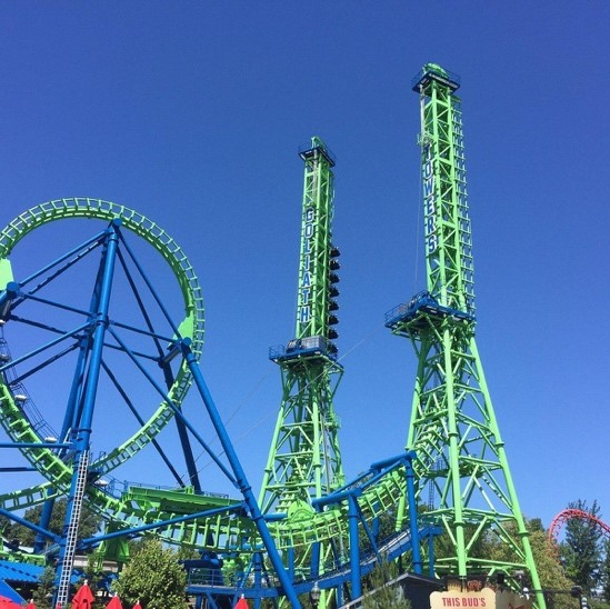 A green and blue roller coaster with two tall towers and a large loop.
