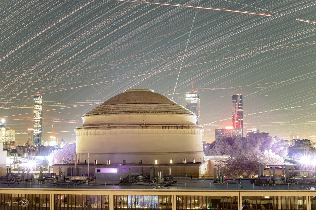This composite image features the MIT Great Dome in front of a sky streaked with star trails.  