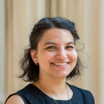 A brow haired woman smiles at the camera