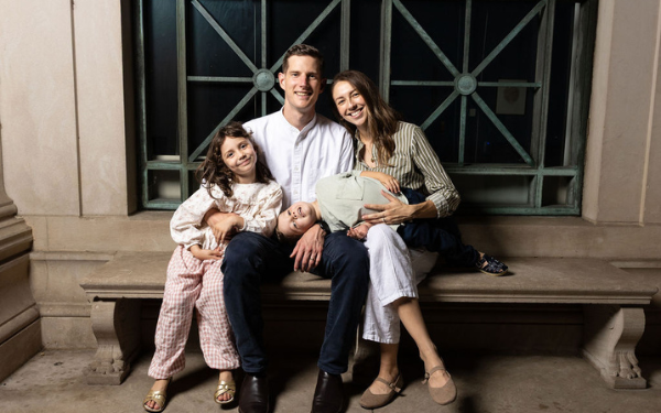 A mother and father pose with their two children- one bouy and one girl